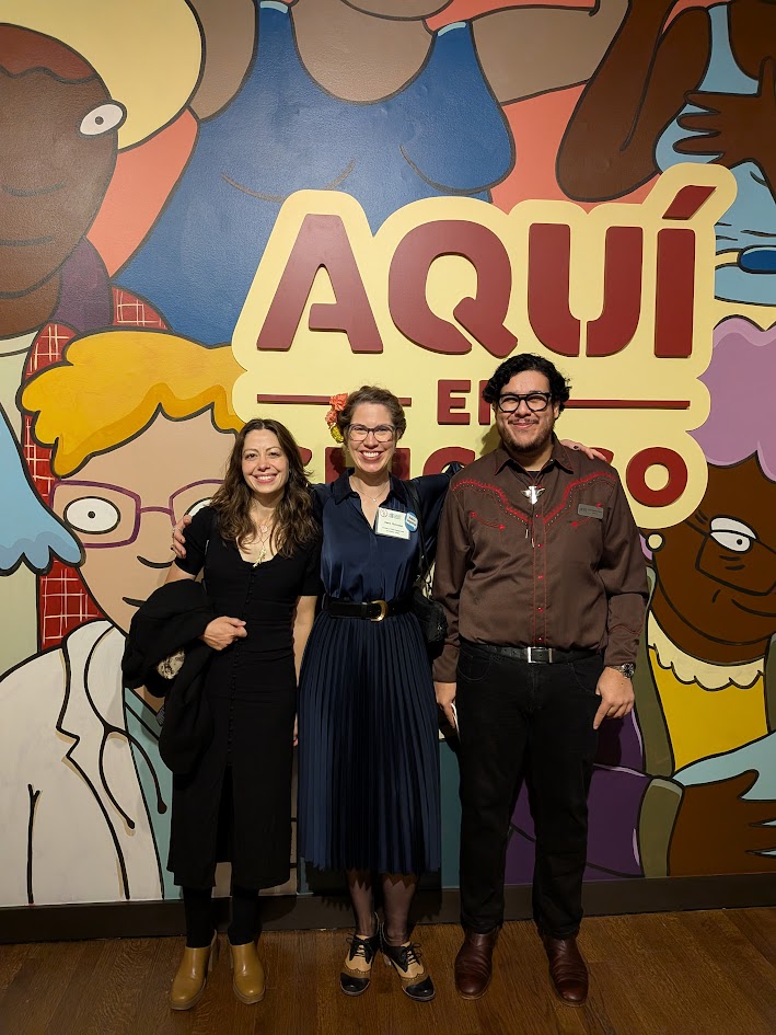 Rebekah Coffman, Elena Gonzales, and Jojo Galv&aacute;n Mora in front of the Aqu&iacute; en Chicago mural at the Chicago History Museum