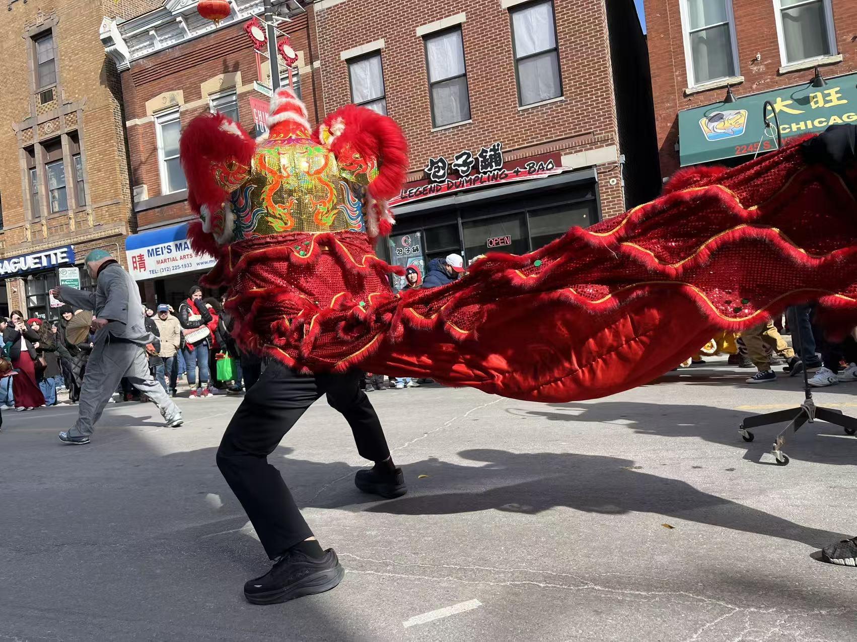 A dragon dancer with a red dragon costume performs at the Lunar New Year Parade