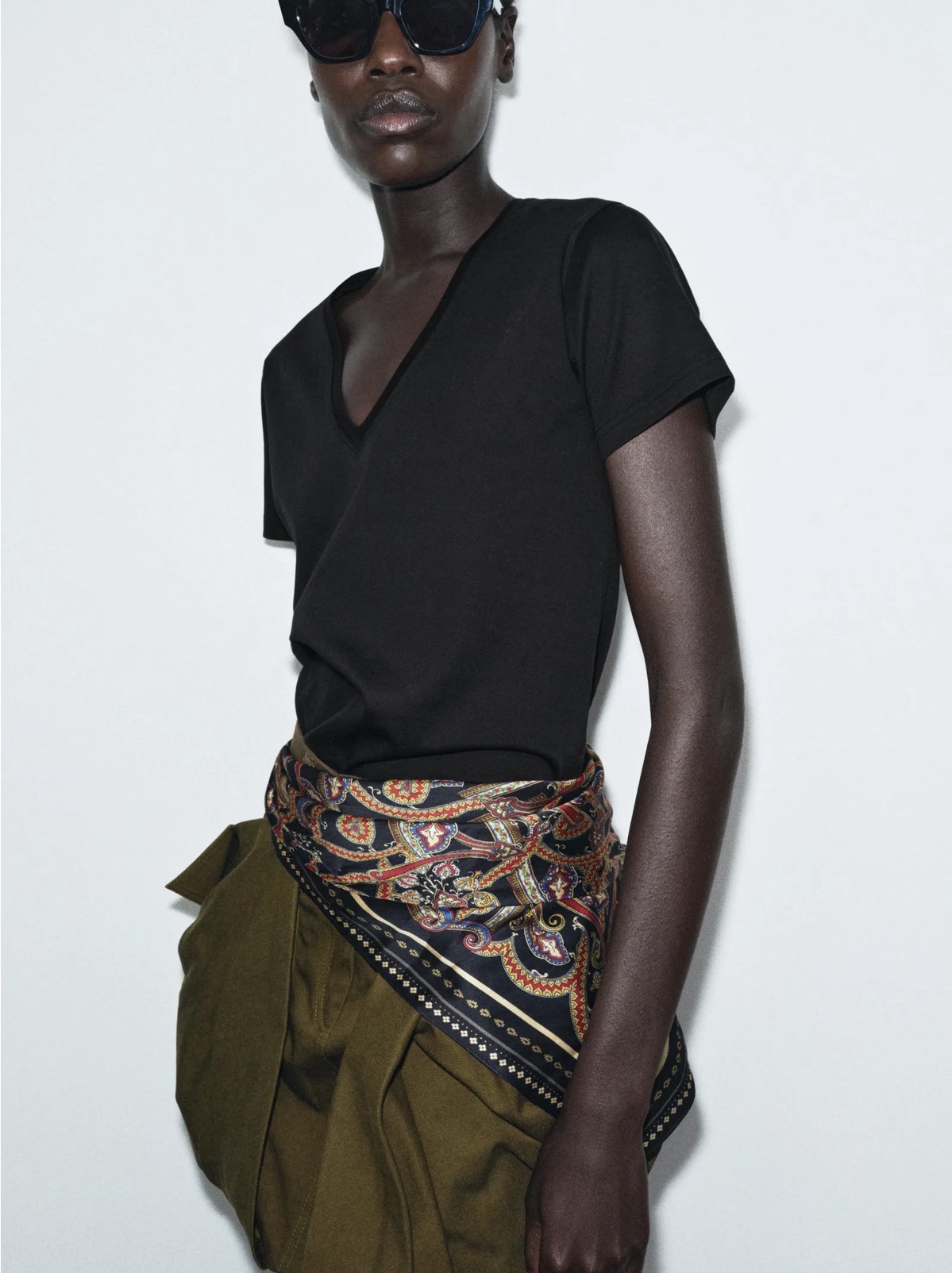 Scarf tied at the waist over black top