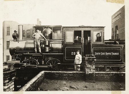 Engineers pose astride an engine used on the first L train in Chicago