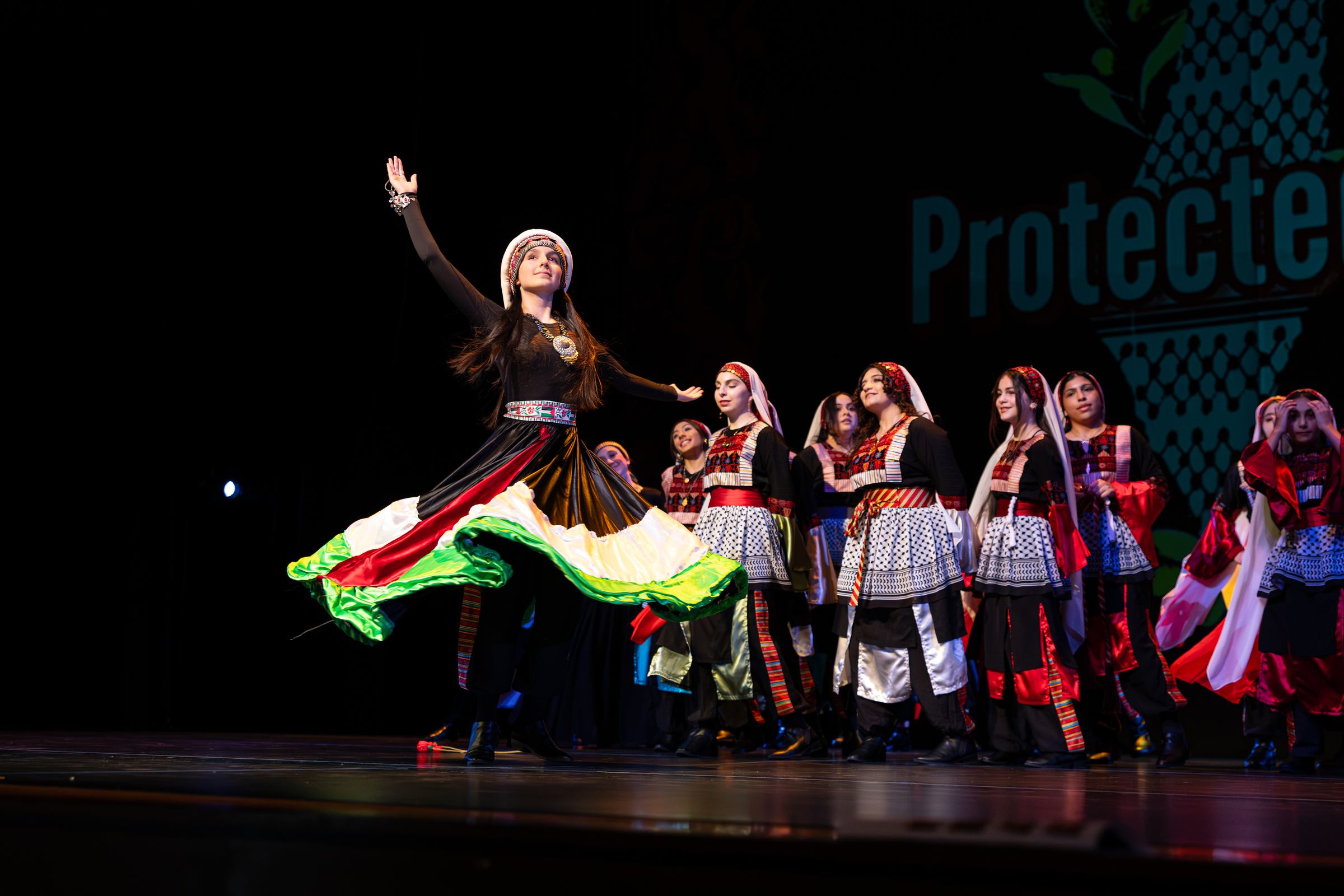 A Canaan Wellspring dancer performing with a Palestinian flag