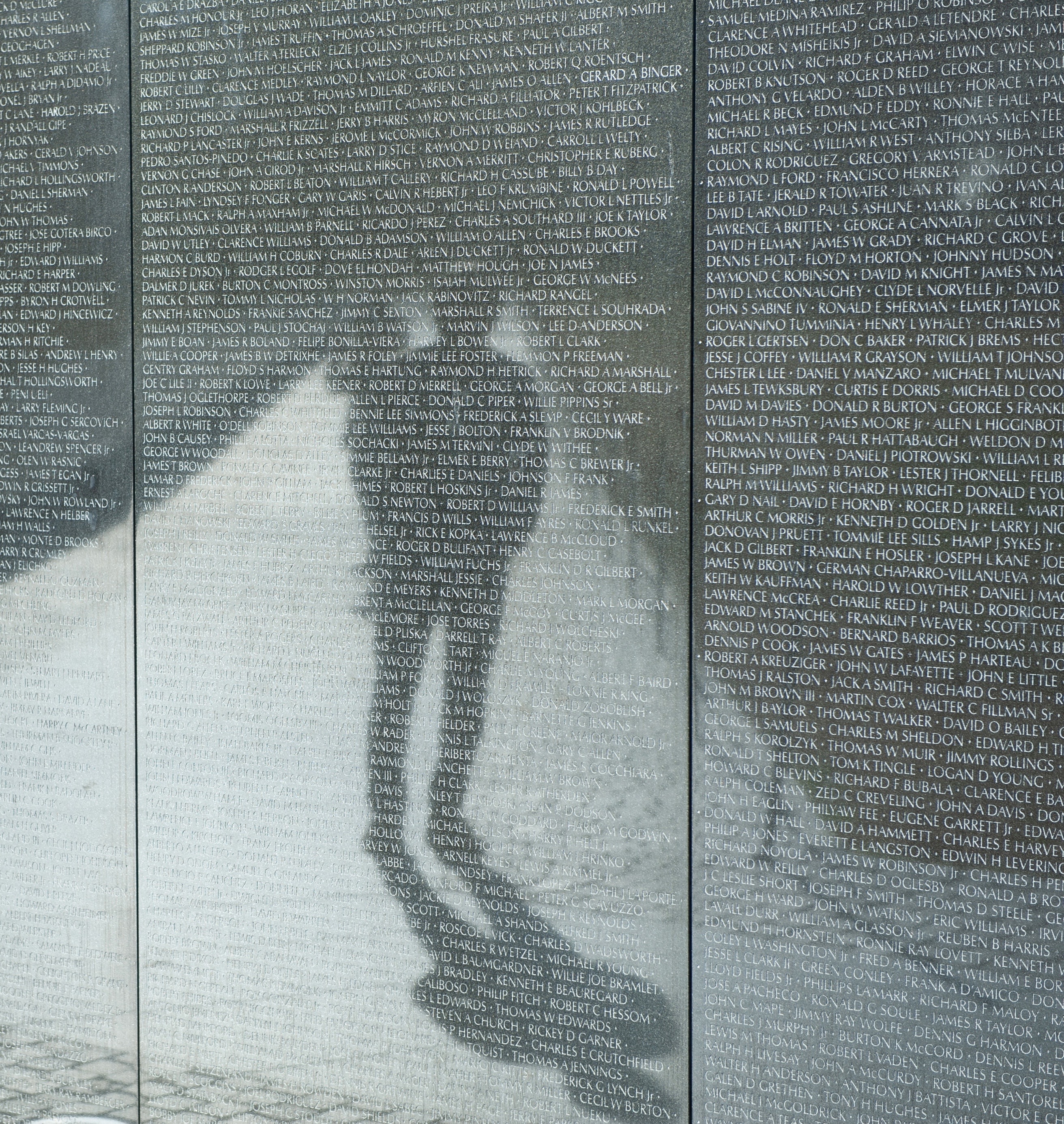 A visitor is reflected on the “Vietnam Veterans Memorial,” Washington DC, March 1, 2022. Courtesy US Department of Defense. Photo: Marvin Lynchard. Public Domain