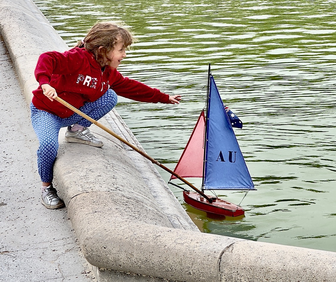 A girl sails a toy boat